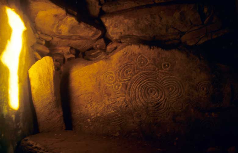 A sunbeam illuminates the art within the neolithic chamber of Cairn L.