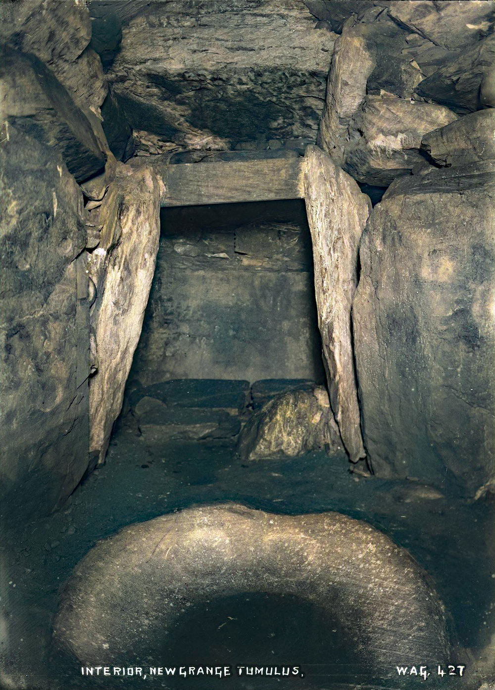 The chamber at Newgrange, showing the fine granite basin which had been moved for a time to the centre of the chamber photographed by William A. Green from Belfast.