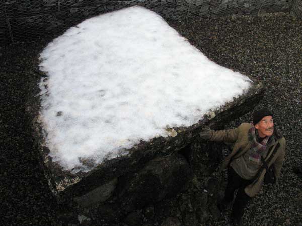 American researcher Martin Brennan and the massive 10 tonne capstone, covered with a sprinkle of snow in 2009.
