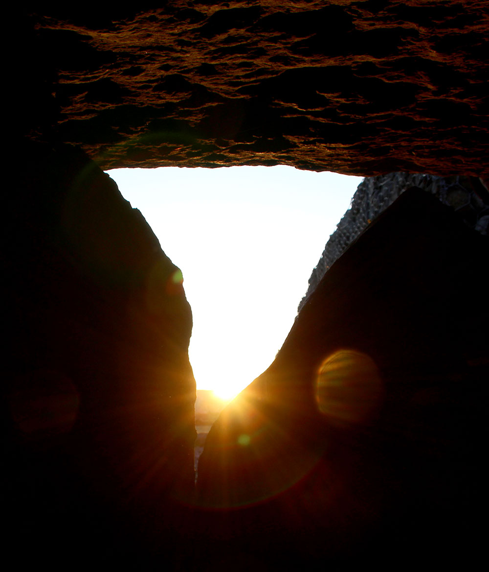 Sunlight illuminates the interior of the womb / chamber at Listoghil.