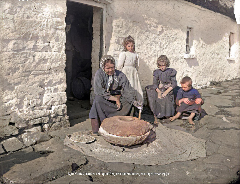 Grinding corn with a hand quern on Inishmurray. Photo by Robert Welch.