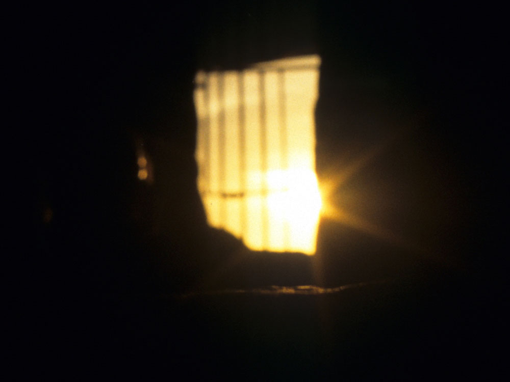 Waiting
        for the sun: view of the equinox sunrise as it enters the passage of Cairn
      T, taken from the rear recess.